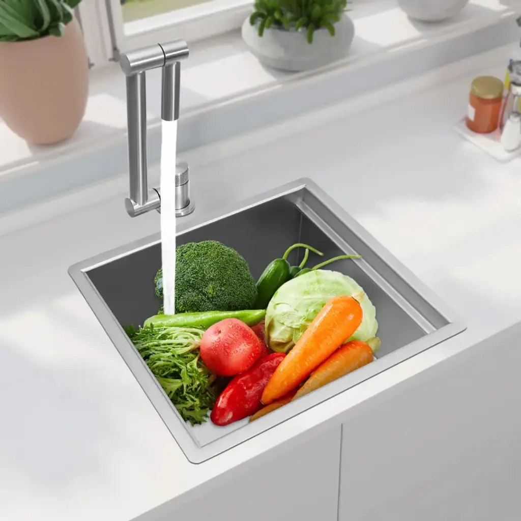 Fresh vegetables in a kitchen sink with running water.