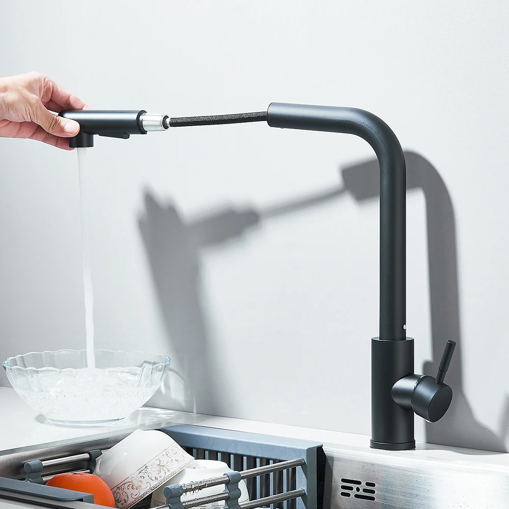 Modern black kitchen faucet with pull-out sprayer in use.