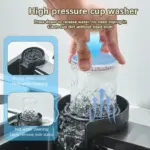 High pressure cup washer with a hand pressing down on a glass, showing water spraying for cleaning.