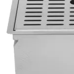 Close-up of a stainless steel drainage grate on a white surface.