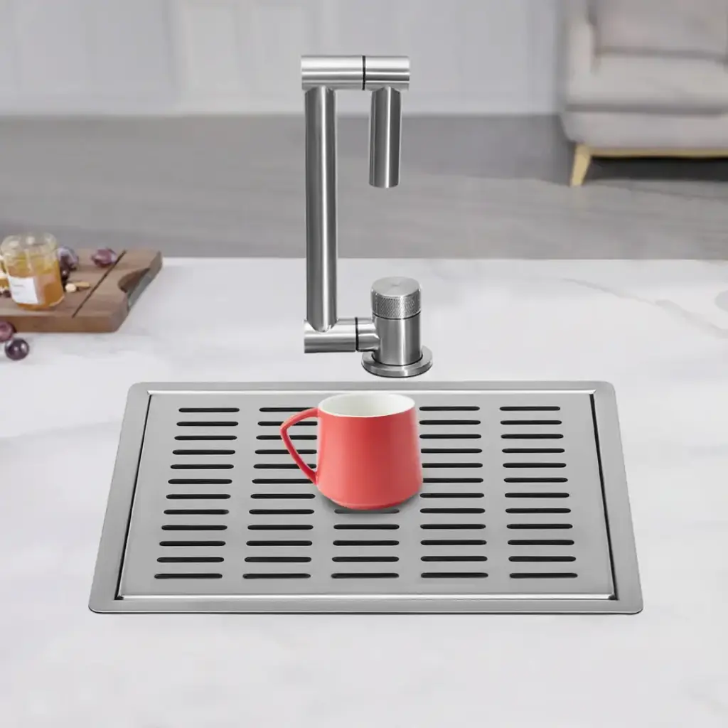 Red mug on a modern kitchen sink with a grid drainboard.