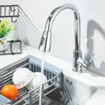 Modern kitchen faucet with running water over a sink.