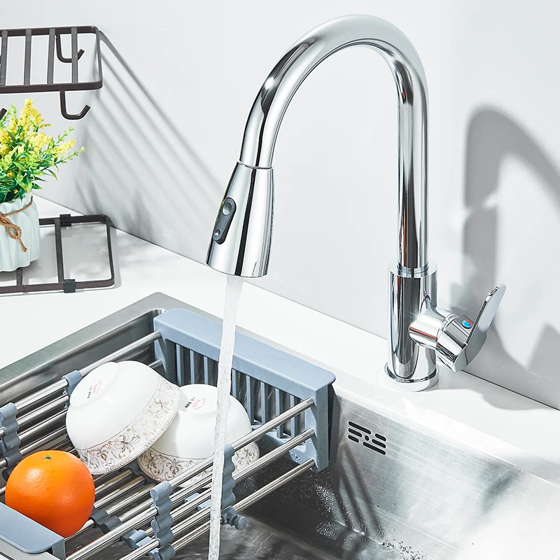 Modern kitchen faucet with running water over a sink.